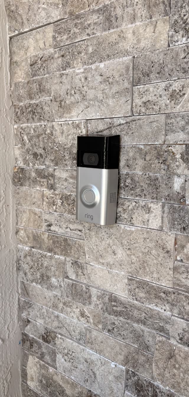 Video doorbell installed on stone wall